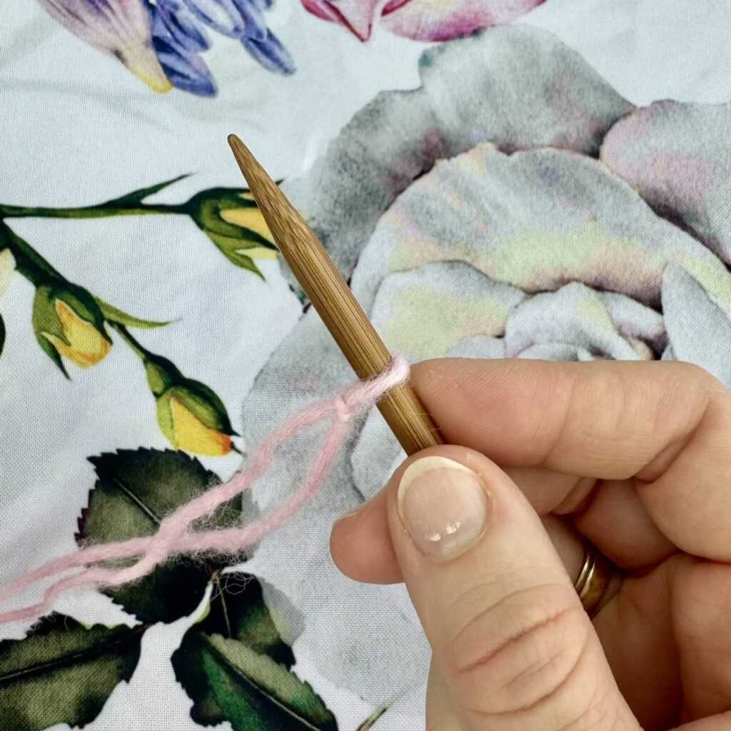 Drewniany drut z narzuconym jednym oczkiem na kwiecistym tle.