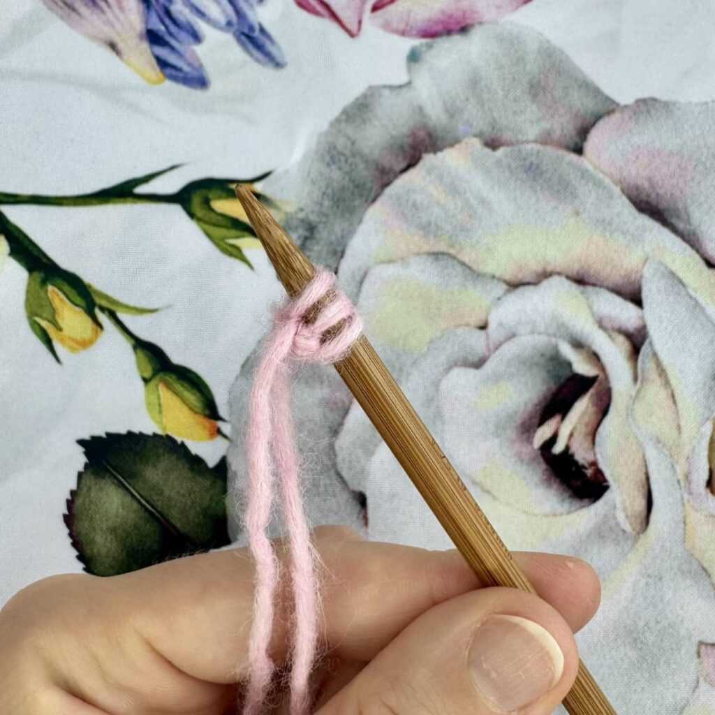 Drewniany drut z narzuconymi trzema oczkami na kwiecistym tle.